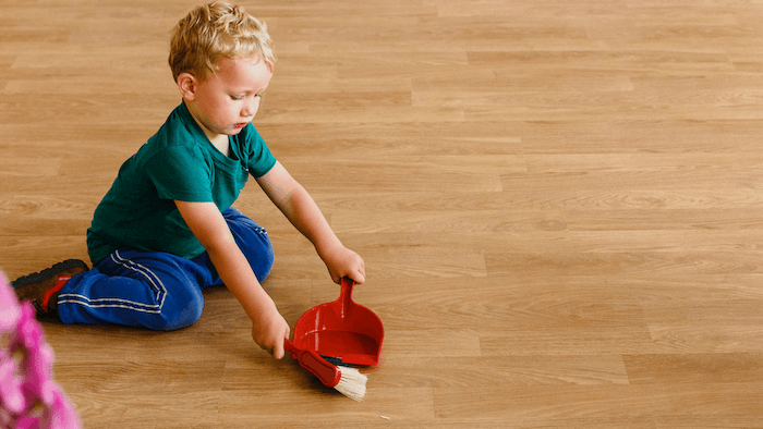 Montessori kid sweeping the floor 
